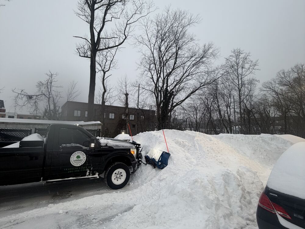 Branded plow truck clearing a large snow pile