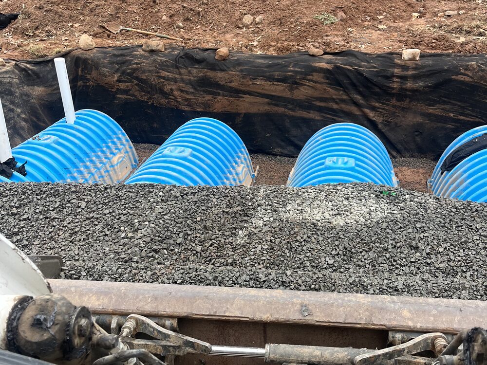 Drainage chambers being installed on a gravel base during a seepage pit install